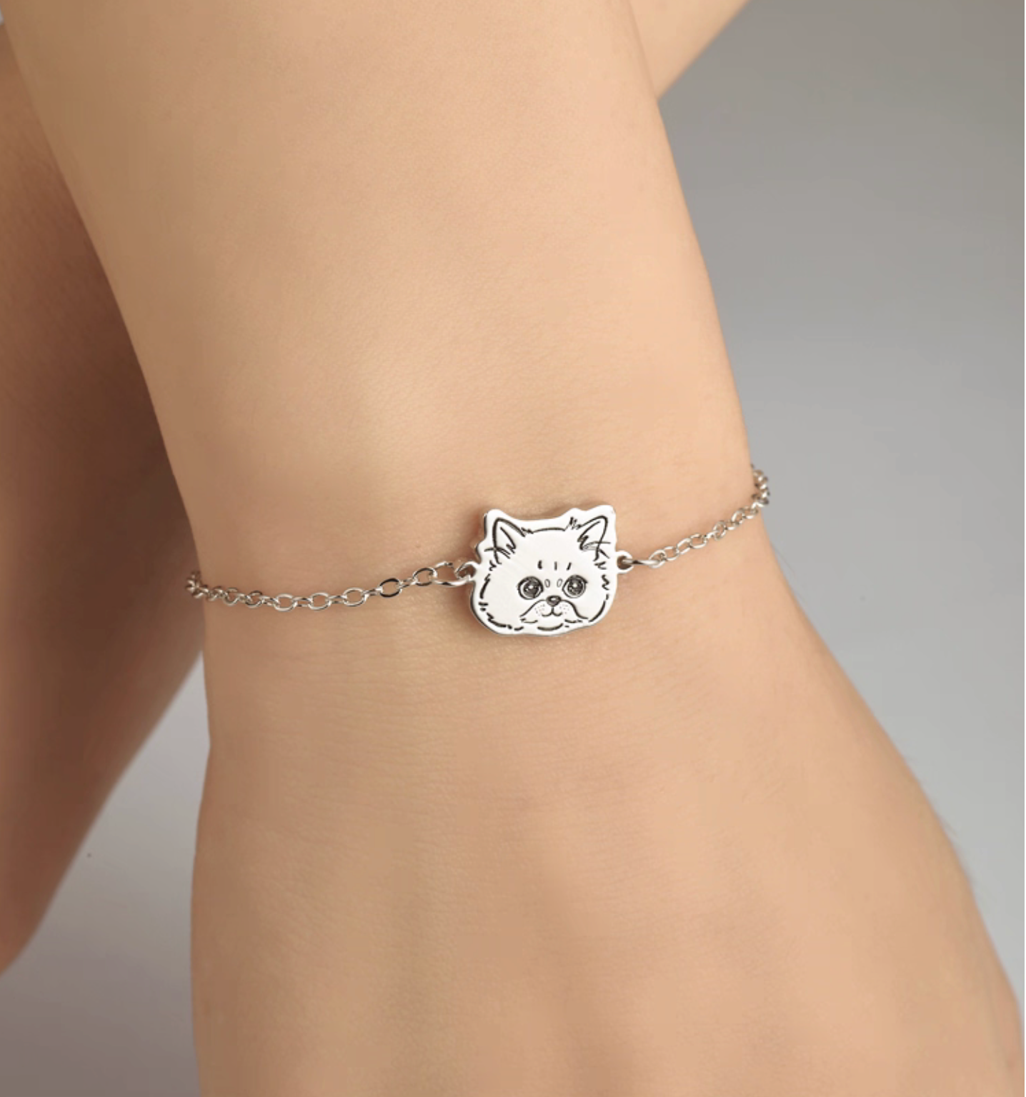 Close-up of hand-engraved cat face on a sterling silver pendant